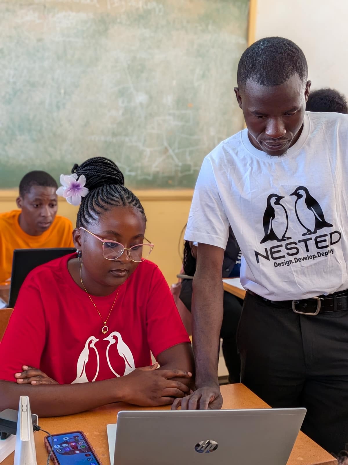 A Nested class in session, a mentor guiding a student on a laptop